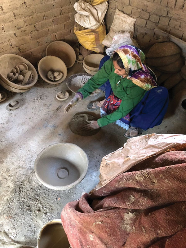 5 Preparing a slab to make the bottom half of the jar. The press mold, with an indentation for the foot ring, is visible in the foreground.