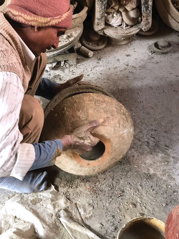 8 A potter joins the two halves of the press mold.