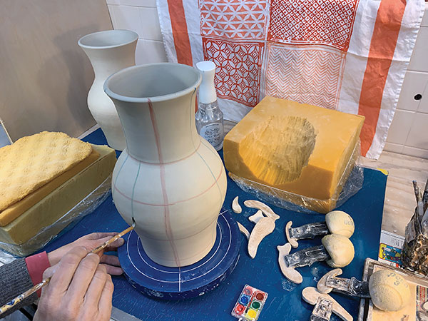 1 Throw a vase form to 16-inches in height, then shape it to 14 inches tall with ¼-inch-thick walls. Divide the pot into a grid by making marks with watercolors.