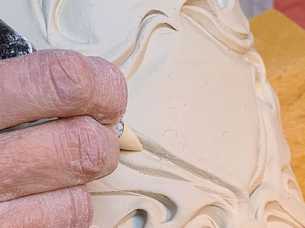 8 Use the clay shaping tool to compress and reinforce small fissures.
