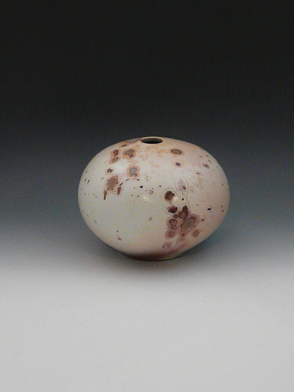 14 Fired vessel (see 11, 13), 6 1/2 in. (17 cm) in diameter, cleaned and waxed porcelain.