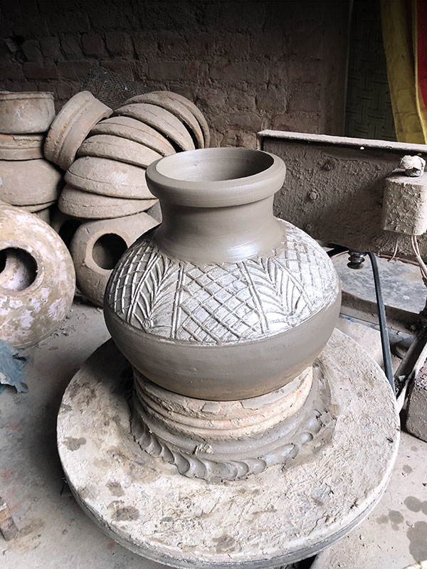 Greenware water jar, press-molded body, thrown neck and rim, mica embellishment. Shown seated in a bisqued ring used to center the jar to add the thrown neck.