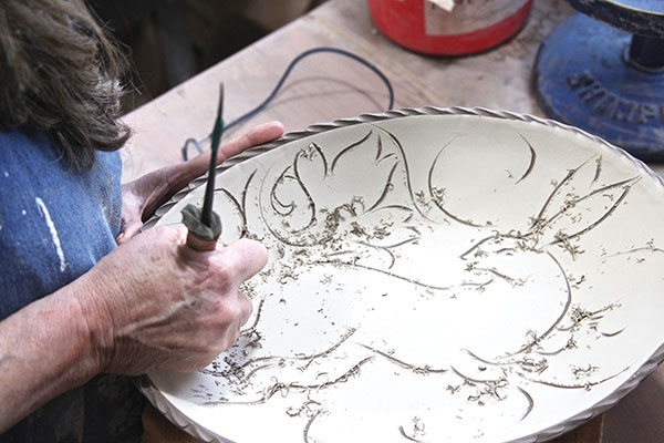 6 Carve out the negative spaces through the slip, back into the clay using 4-inch length of bamboo, with the inner pith shaved down to a ¼-inch end in the shape of a flat-head screwdriver.