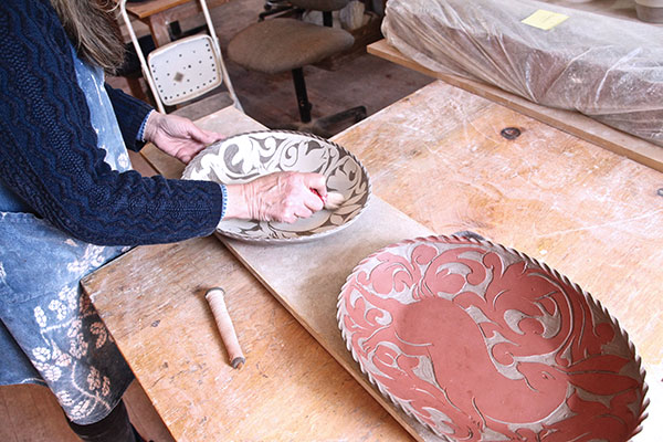 6 Carve out the negative spaces through the slip, back into the clay using 4-inch length of bamboo, with the inner pith shaved down to a ¼-inch end in the shape of a flat-head screwdriver.
