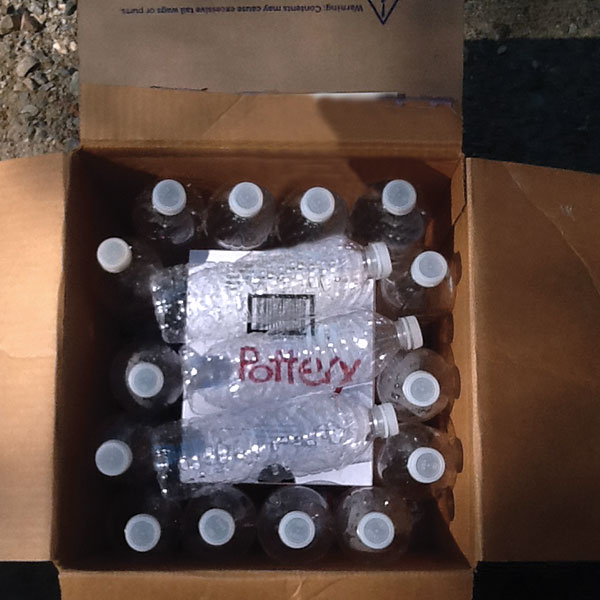 3 Lay additional plastic bottles on the top face of the interior box. The outer box is now ready to be taped shut, and the packed work can be shipped securely.