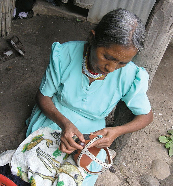5 Potter burnishing the painted candle holder. Photo: Ruth Rosenfeld.