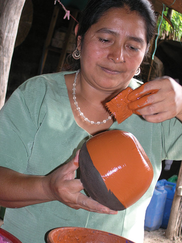 2 Juana applying red slip. Photo: Ruth Rosenfeld.