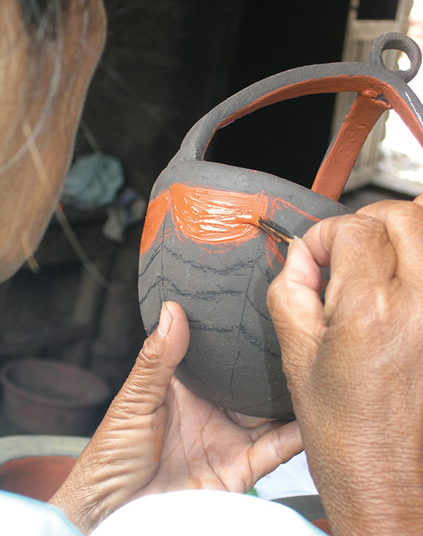 4 A San Luis Jilotepeque potter painting one of the candle holders. Photo: Ruth Rosenfeld.