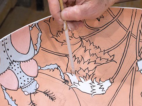 3 Apply glaze with a brush by jiggling the glaze onto the surface. The fluid glaze is contained by the wax lines.