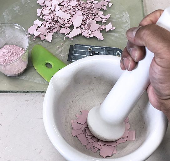 3 Grind the dry glaze chunks with a mortar and pestle until you form a powder.
