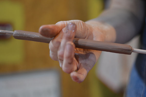 6 Wrap and pinch clay around a dowel, then pull the clay like a handle.