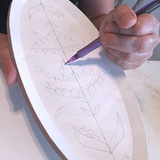 7 Draw out a decorative pattern with pencil over the underglaze.
