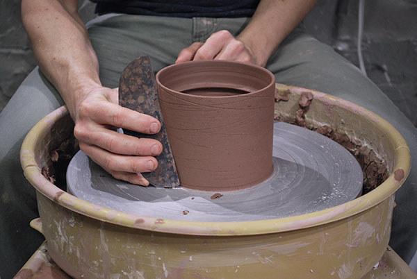 7 Use a metal rib held against the surface to drag coarse grog, creating lines. 