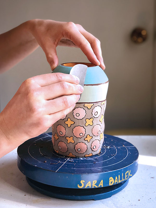 14 Spin the piece while applying pressure with a metal rib to reveal the clay body.