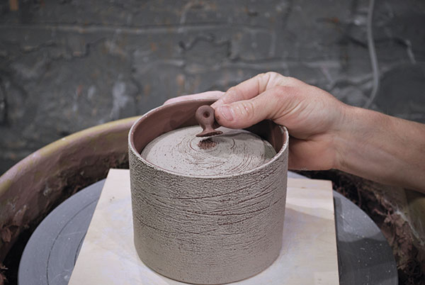 12 Add a knob to the lid after the slip has been added to the surface. 