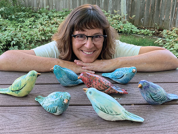 1 Clay artist and potter Rita Vali takes a moment with a flock of Hopeful Birds destined for Jackson, Wyoming.