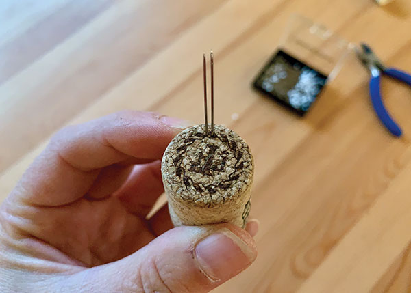 2 Insert pins into the cork, sharp ends up and in close pairs.