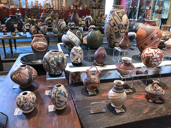 6 Assorted pottery from Mata Ortiz, Chihuahua. Foreground (left to right): Leticia Ledezma Loya’s two small pots with butterflies, Alonso Sandoval’s small white pot with swirls, and Jorge Corona’s vessel.