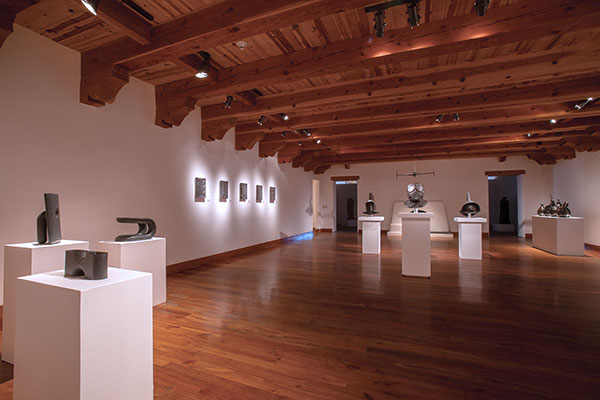 Installation view of Shadow at Gerald Peters Gallery. Works shown, from left to right: Del Harrow (on pedestals), Cary Esser (on the wall), and Ben Jackel (on pedestals and suspended from the ceiling).