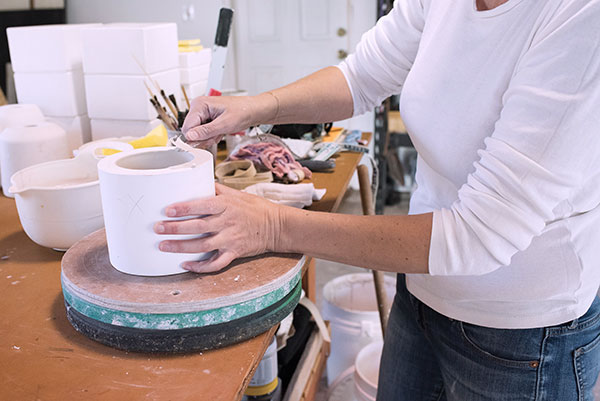 4 Clean the excess clay from the top of the plaster mold with a sharp knife. Cut the excess with an outward motion to avoid ripping the wall of the piece.