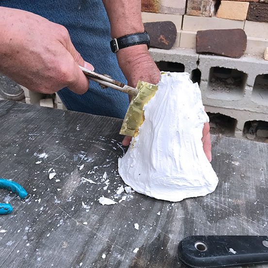3 Once the plaster is set, use pliers to pull the shims out of the mold.