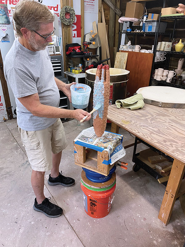 16 Use a wide brush to apply a thin coat of a second color of glaze over the surface of the piece.