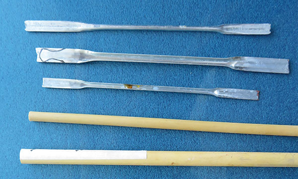 2 Flatten the ends of the metal umbrella pieces with a hammer and draw the desired tool shape in marker. Gather narrow lengths of bamboo or old liner brushes to make handles for shorter metal parts.