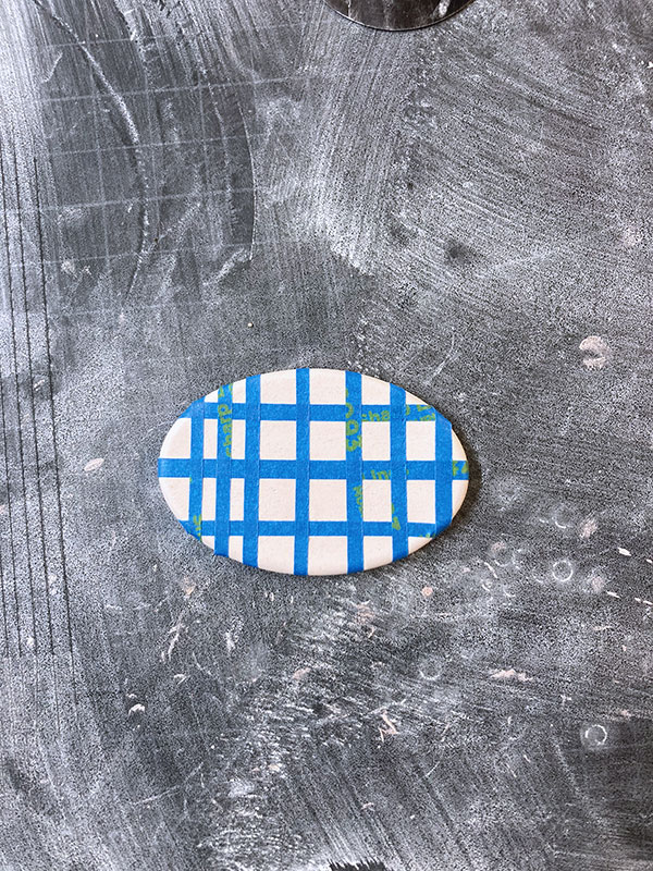 3 After bisque firing, use masking tape to create a resist design on your surface.