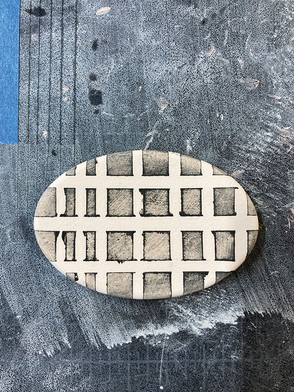 5 Wipe away the underglaze to get a stained effect and then remove the tape.