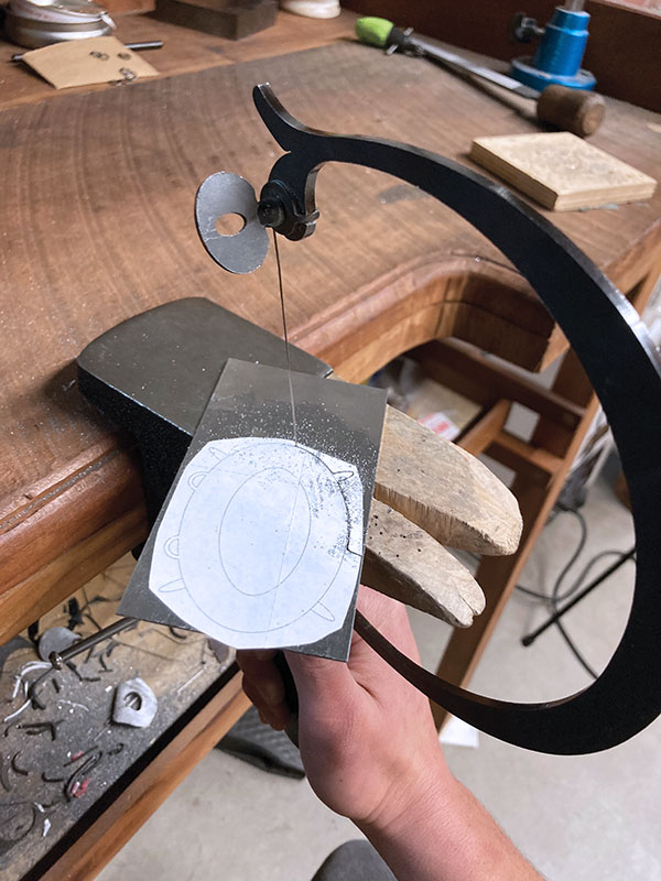 7 Draw the outline, prongs, and bails on paper, secure it to the steel, then cut it out.