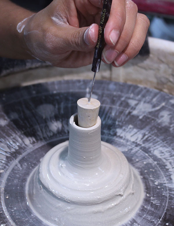 6 Throw a very narrow cylinder off the hump. The cylinder should fit the widest part of the cork intended to fit after firing