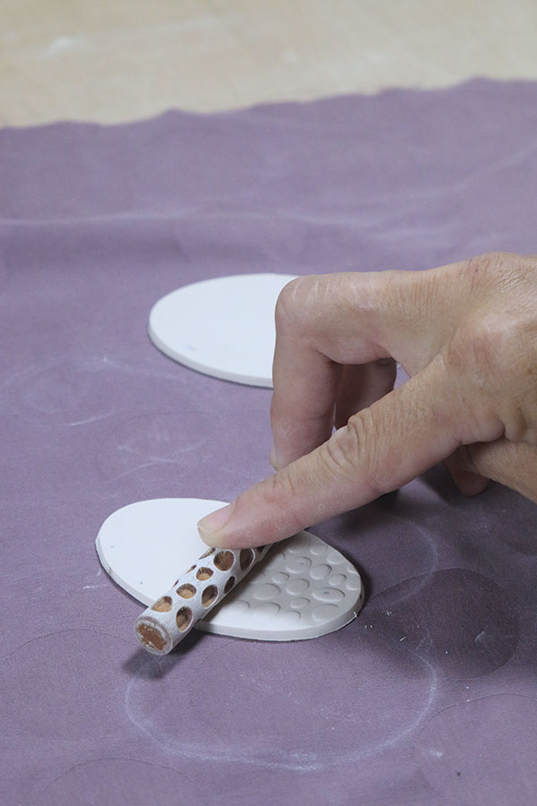 8 Add texture to the bottom oval slab. Be careful not to thin the slab while texturing it. Score, slip, and join it to the body.