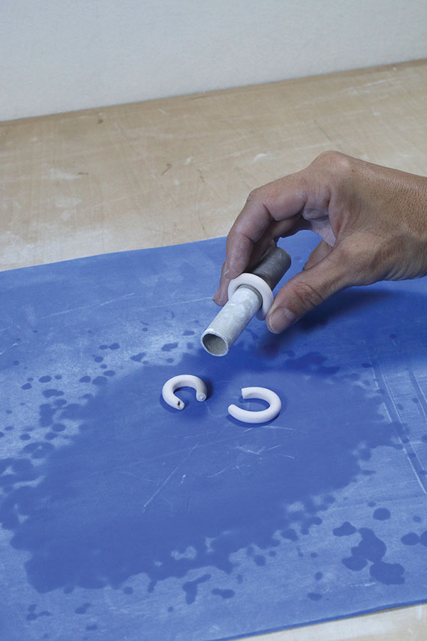 11 Roll thin coils of clay to make small handles. Wrap the coils around a cylinder to create a nice arch in the handles.