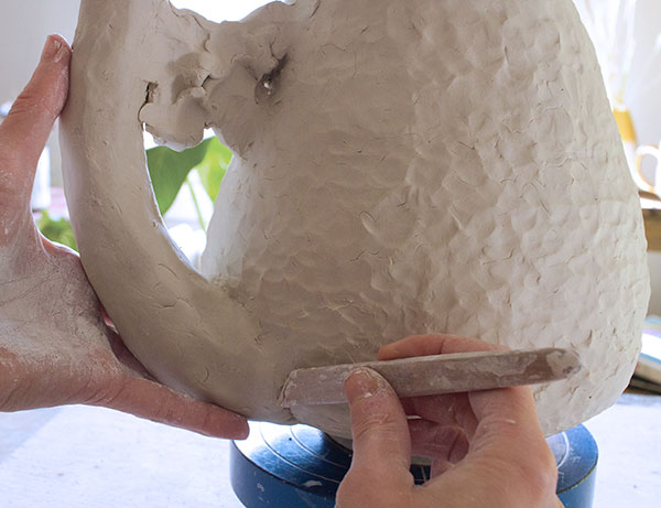 10 Add the handle, then work the seams well to blend the joins. Add light finger texture to the blended seam areas.