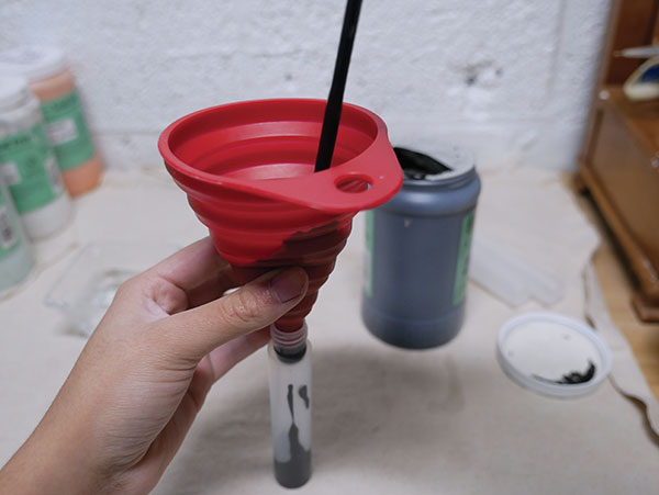 1 Using a funnel, pour in underglaze, and use a paintbrush to push it through.