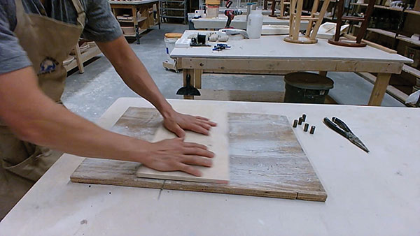 3 Using two pieces of plywood, roll the warped thermocouple rod back and forth to straighten.
