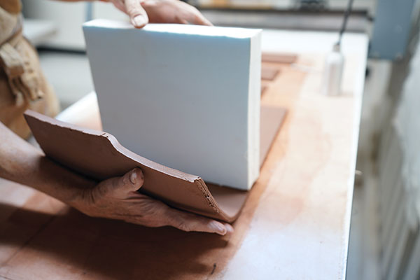 1 Form the bottle by pressing a rolled slab against a foam cube block.