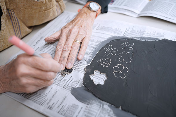 9 Incise flowers in a thin slab coated with black underglaze, and the cut out the flower.