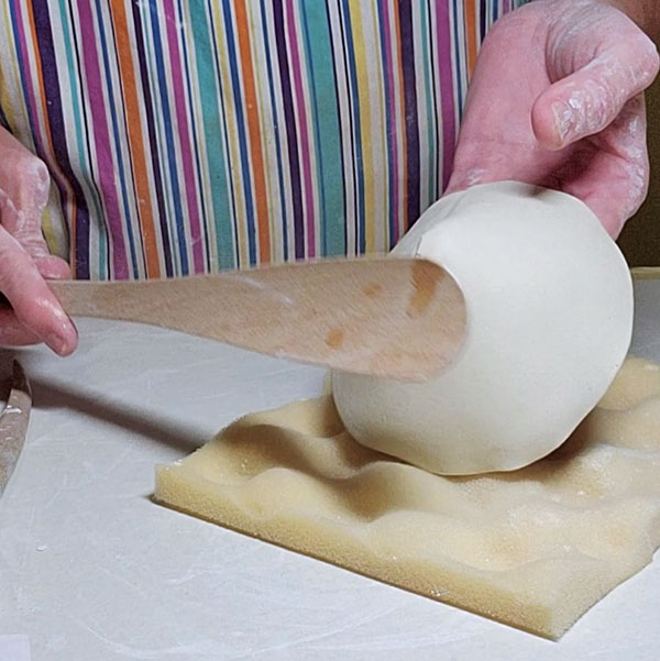 2 Compress the cone tip with a roller, then paddle it to avoid cracks forming.