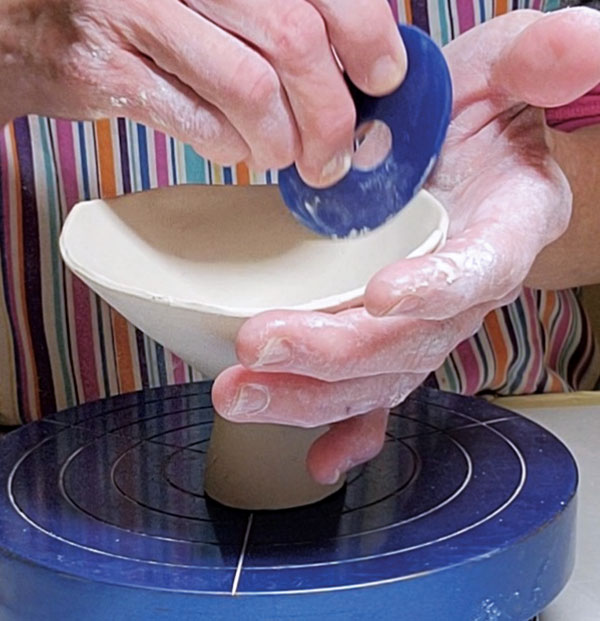 4 Attach the foot, then reshape the cup form using the curved end of a rubber rib.