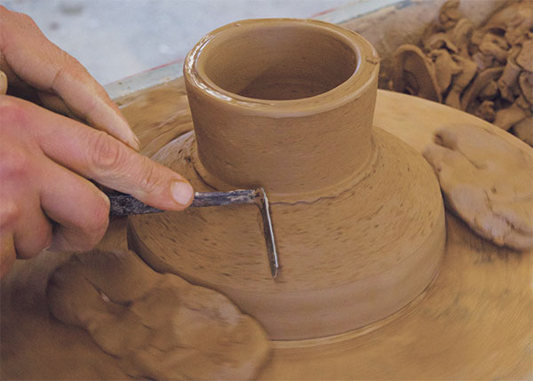 6 Now the fun part! Cut away the excess clay outside the foot to reveal the profile.