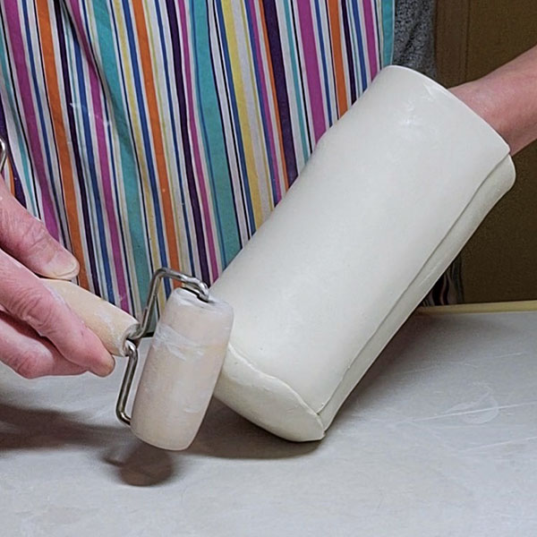 7 Attach base to the pitcher body. Compress with a roller to form a rounded base.