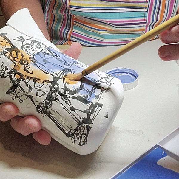 12 Brush watered-down underglazes over the drawings to add color and dimension.