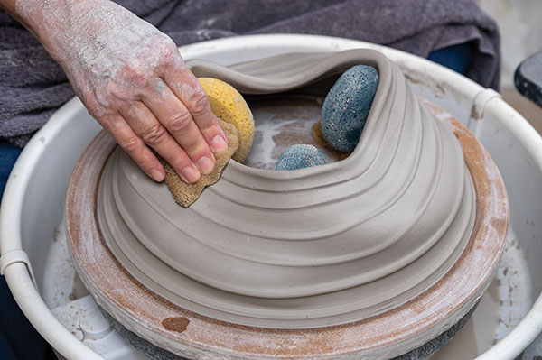 6 After the piece firms up enough to support a controlled collapse, apply a downward pressure between the feet.
