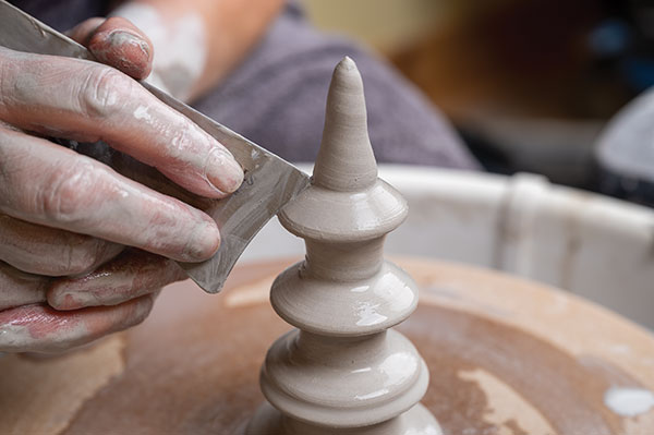 10 The finial begins as a solid cone shape. Start at the bottom and indent with a variety of ribs. Smooth after each indent.