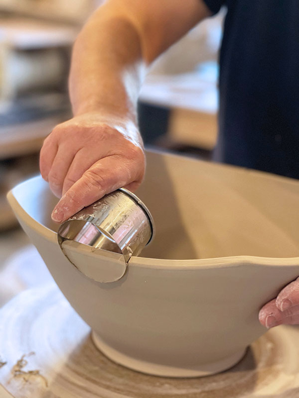 5 Now that the rim is compressed, use a ruler to mark the middle of the sides of the bowl and use a circle cutter to cut a half circle in the rim where the handles will be added.