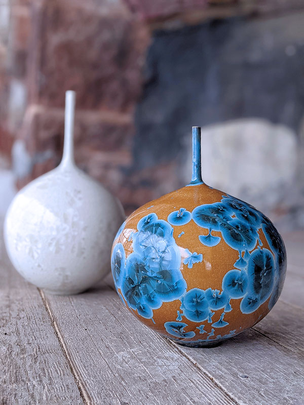 11 Drew Darley’s nickel crystalline bottle and white crystalline bottle, to 14 in. (36 cm) in height, wheel-thrown porcelain, crystalline glaze, fired to cone 11 in oxidation.