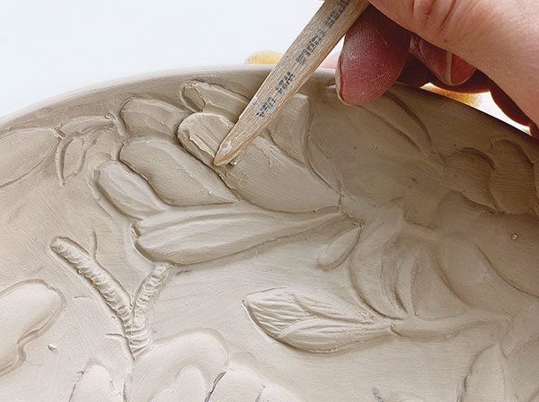 7 Refine the background relief with detail tools, then add clay to build up areas if needed, compress, and sponge smooth.