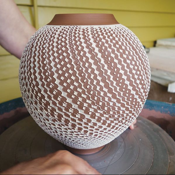 17 Cut the pot off the wheel head using a wire tool. Lift the pot from the wheel and set it aside to dry.