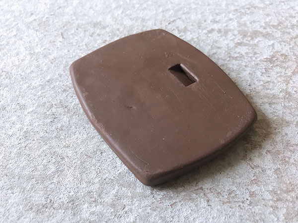 8 Angled notch carved into the back of a leather-hard tile. For best results, center the notch and compress the top edge well.